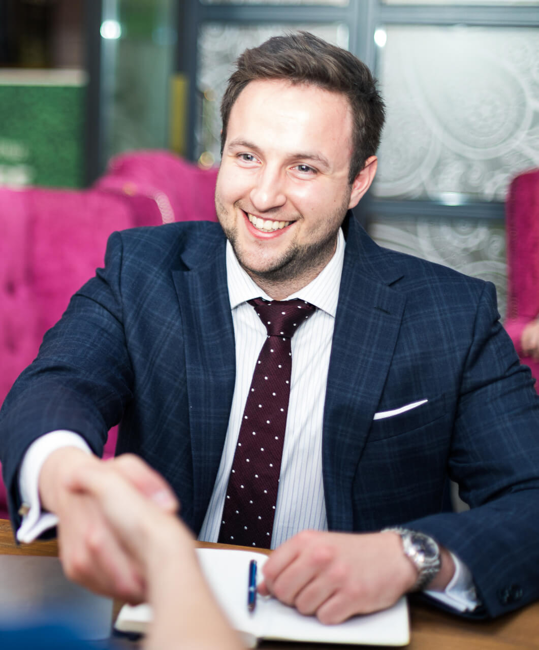 A man smiling while having a handshake with someone