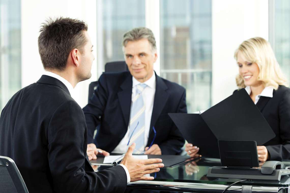 a man being interviewed with a panel of interviewers