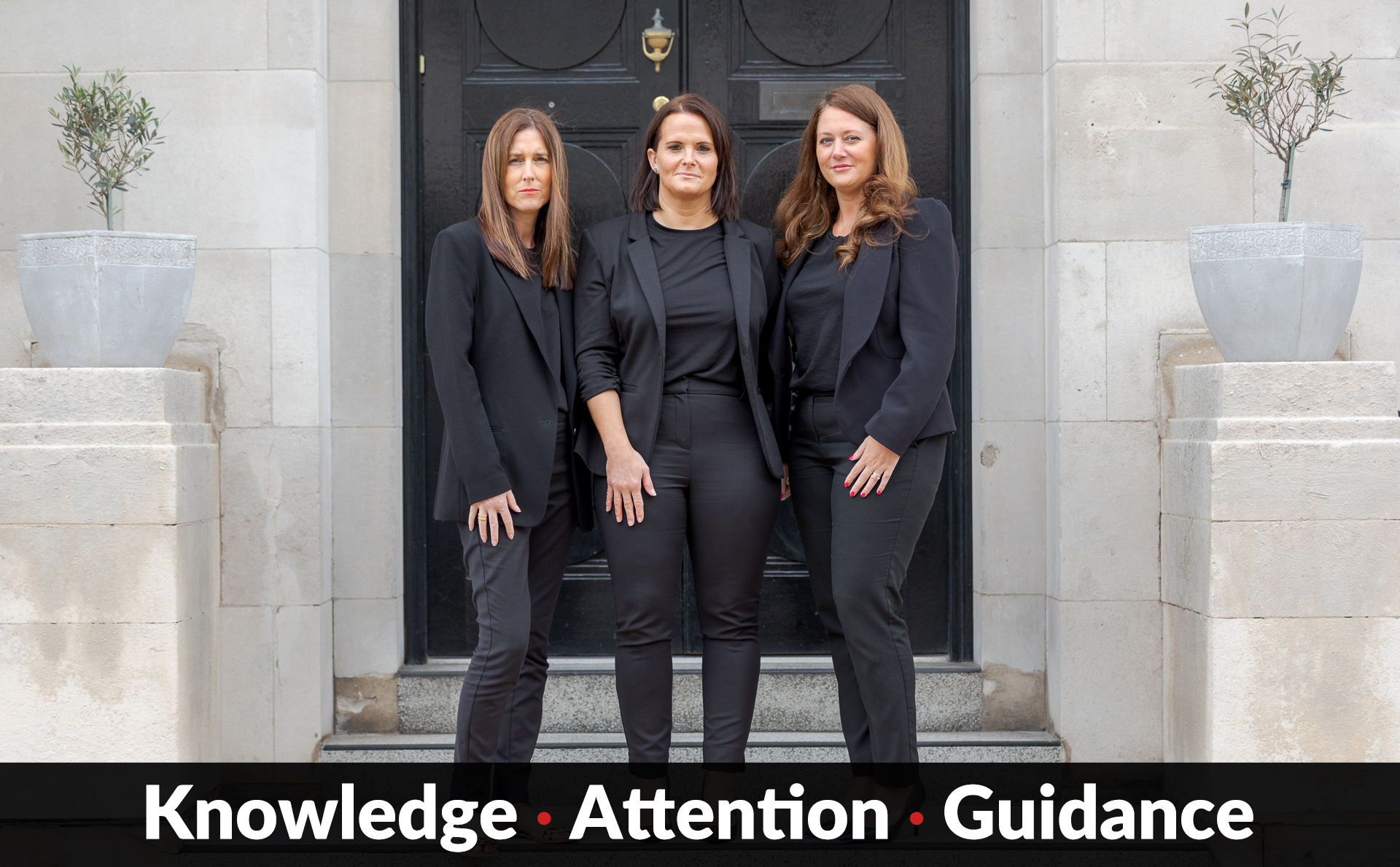 3 women standing aside each other in front of a door