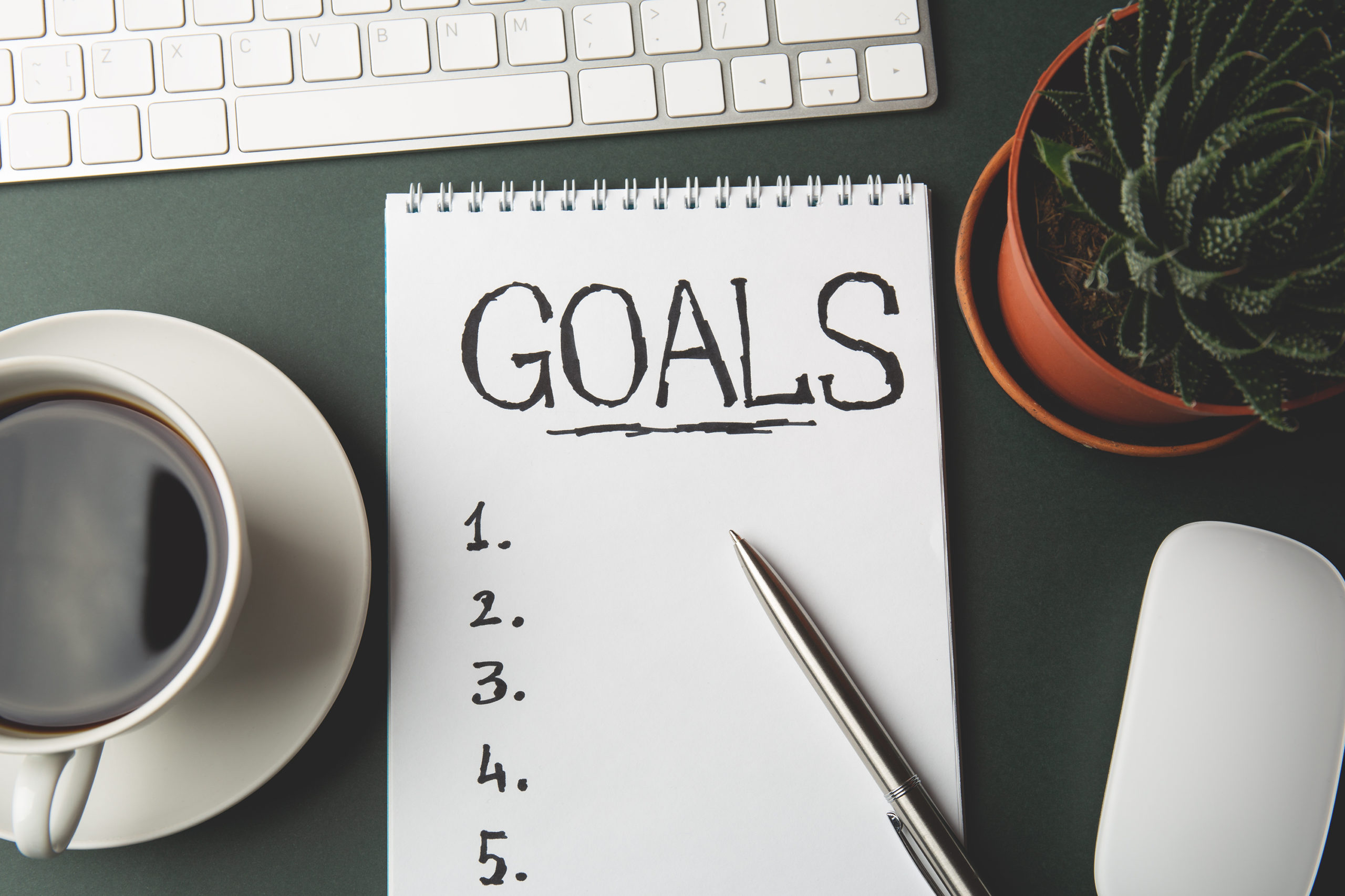 Top view of GOALS list on notepad on dark table, business success inspiration and motivation concept 2 sign board that says "stressed" and "relaxed"